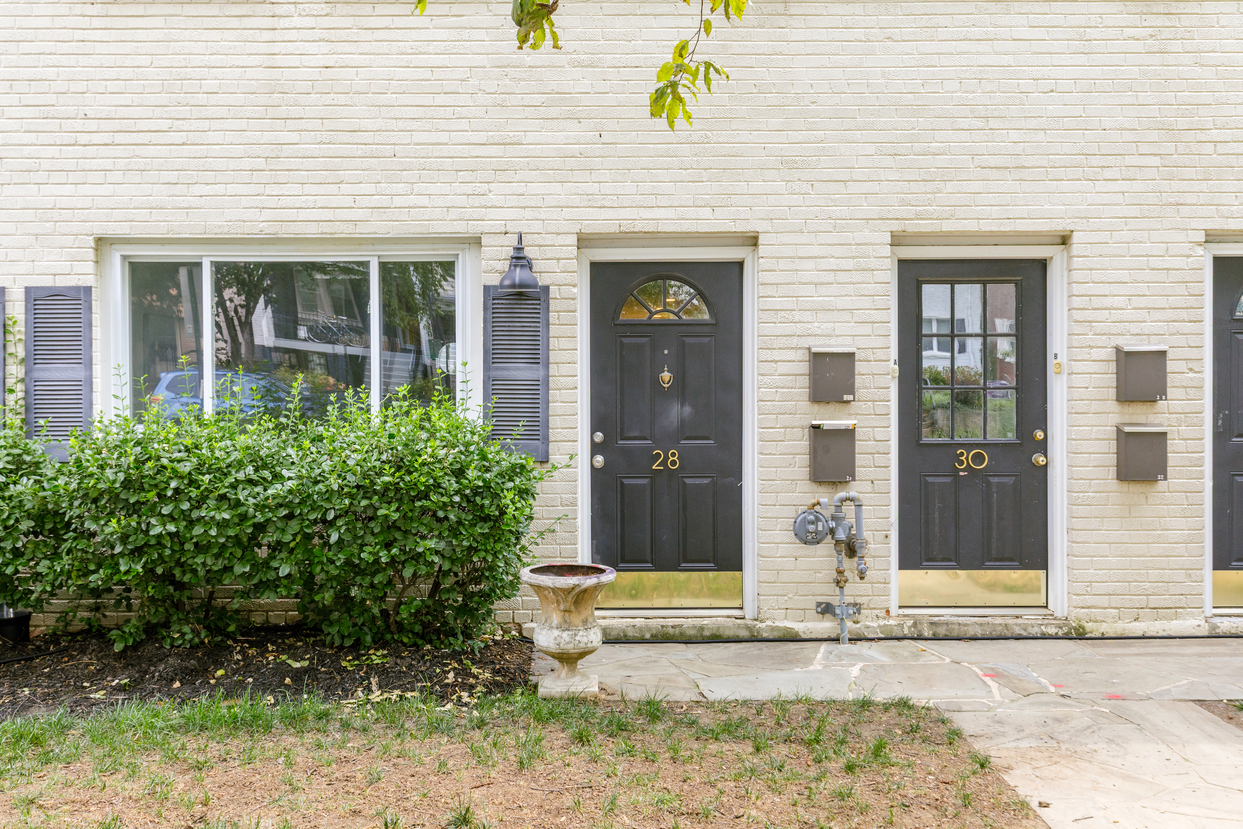 Cream brick townhouse exterior with black doors